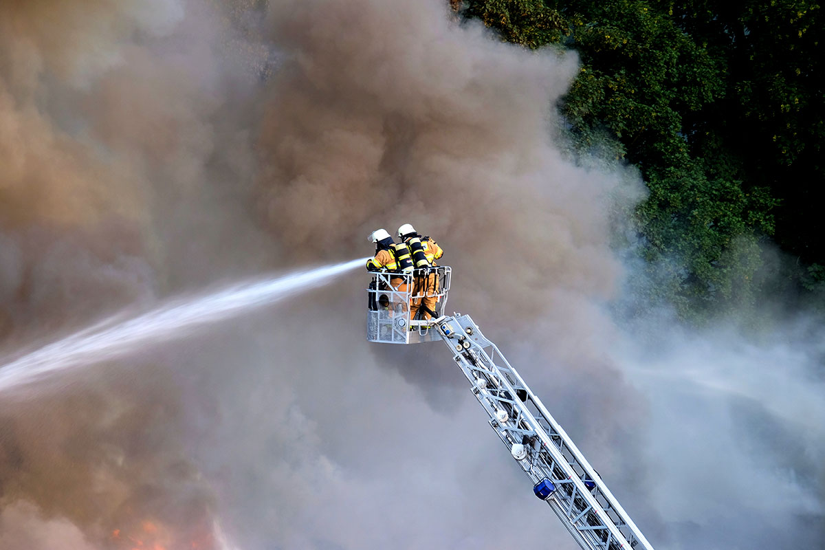 Bomberos extinguen un fuego subidos a una cesta de altura