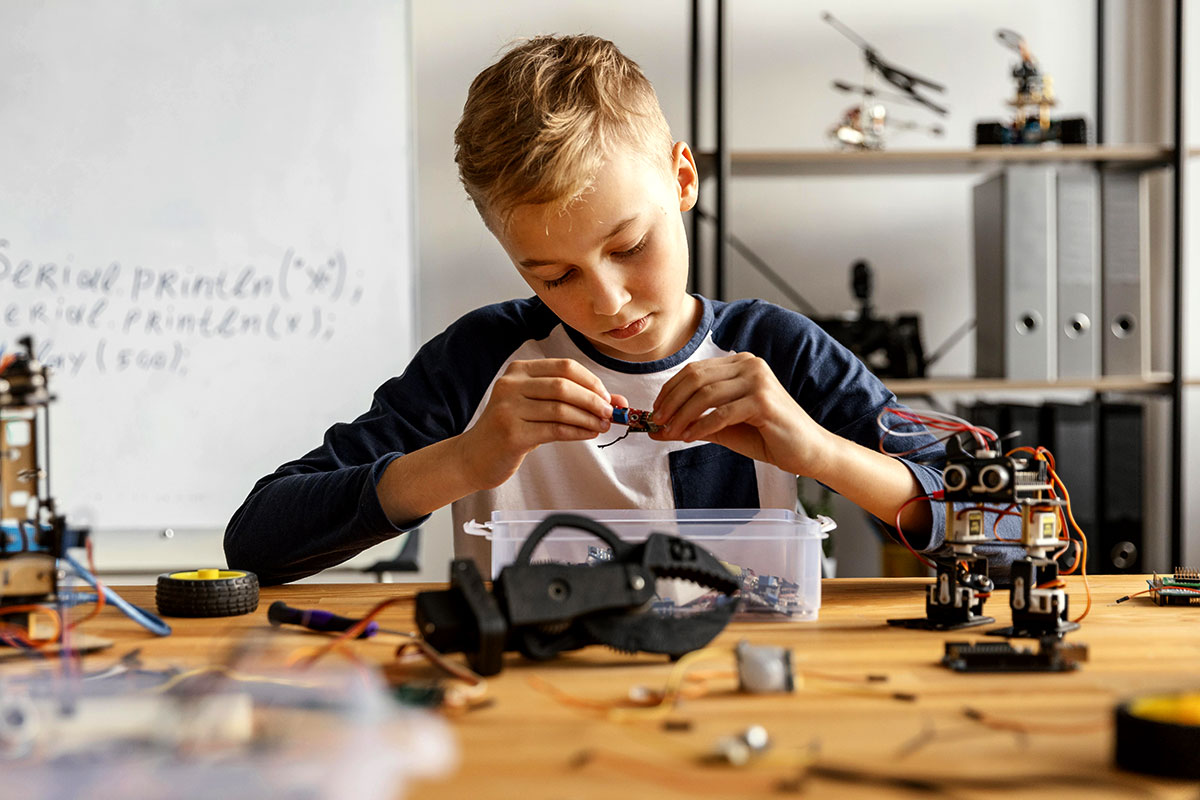 Un niño en una clase de robótica manipula un robot