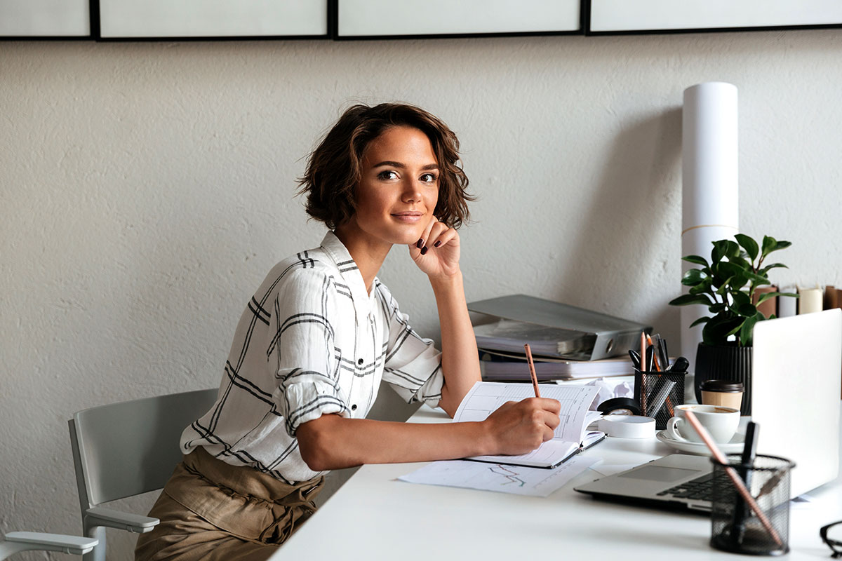 Mujer joven sentada delante de su escritorio