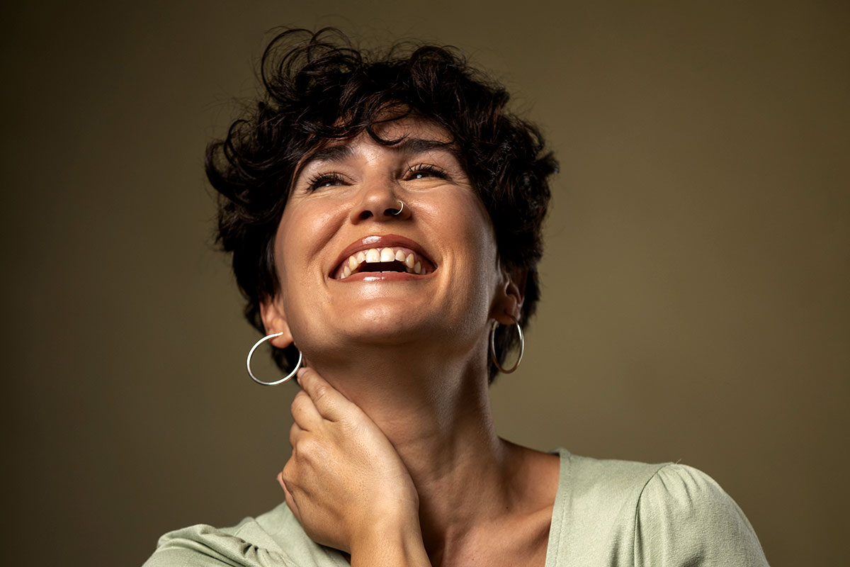 Una mujer sonriendo con actitud relajada